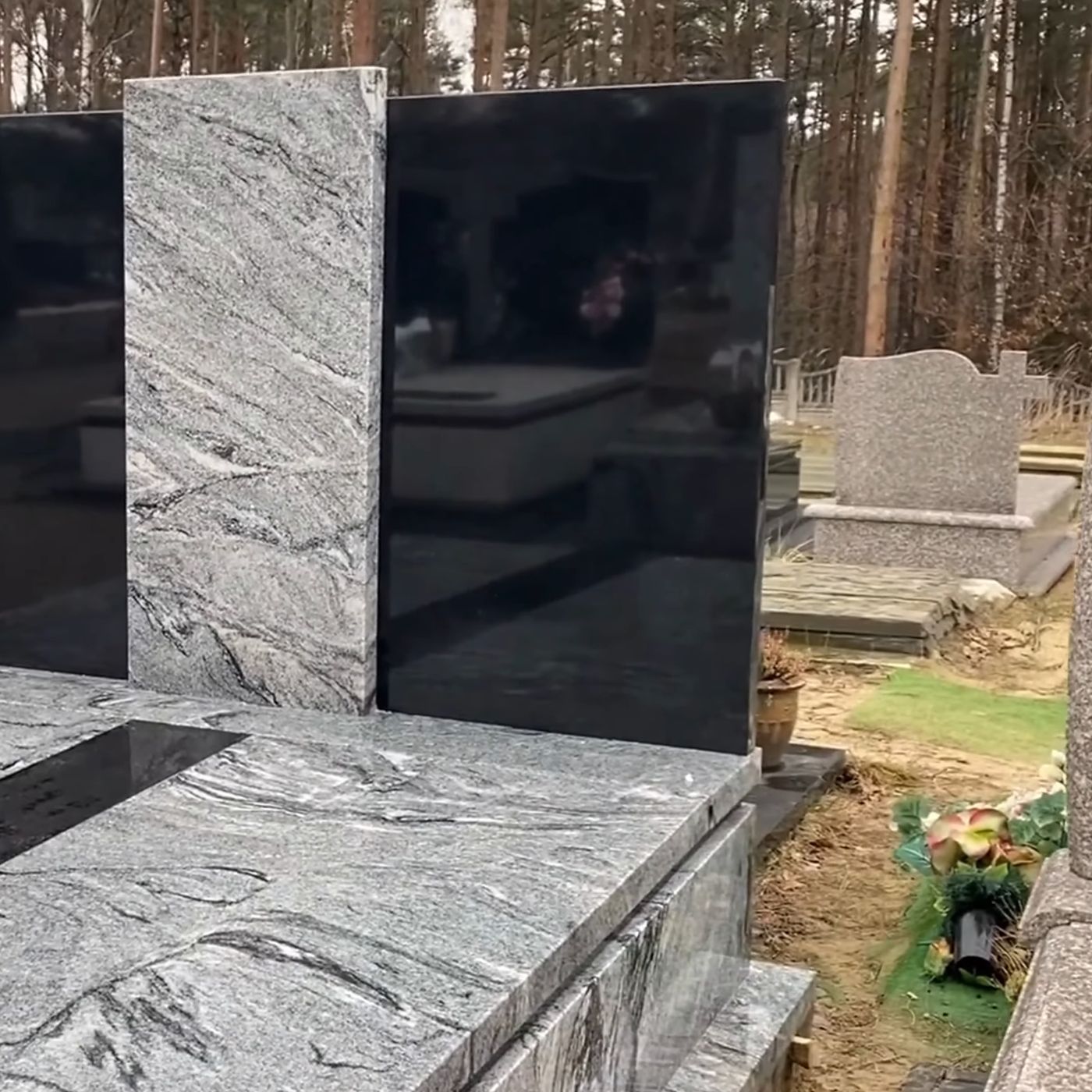 Nagrobek z szarego granitu z dwiema czarnymi, gładko polerowanymi tablicami